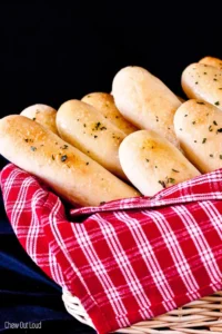 olive garden bread sticks in a basket with a red and white napkin