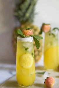 2 Pineberry-Pineapple Mint Coolers with a pineapple in the background