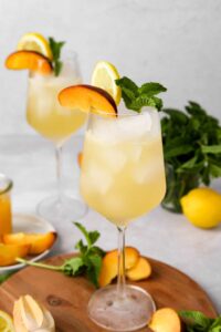 white wine peach spriters in 2 glasses