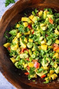 mango and avocado salad in a wooden bowl