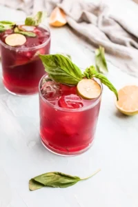 2 cherry limeades with ice and mint leaves and limes