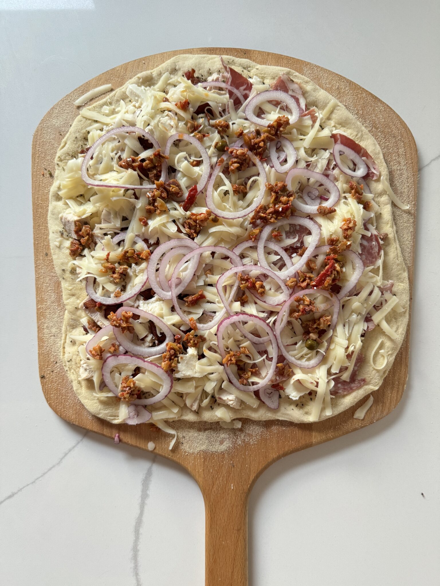 pizza dough rolled out and covered with toppings