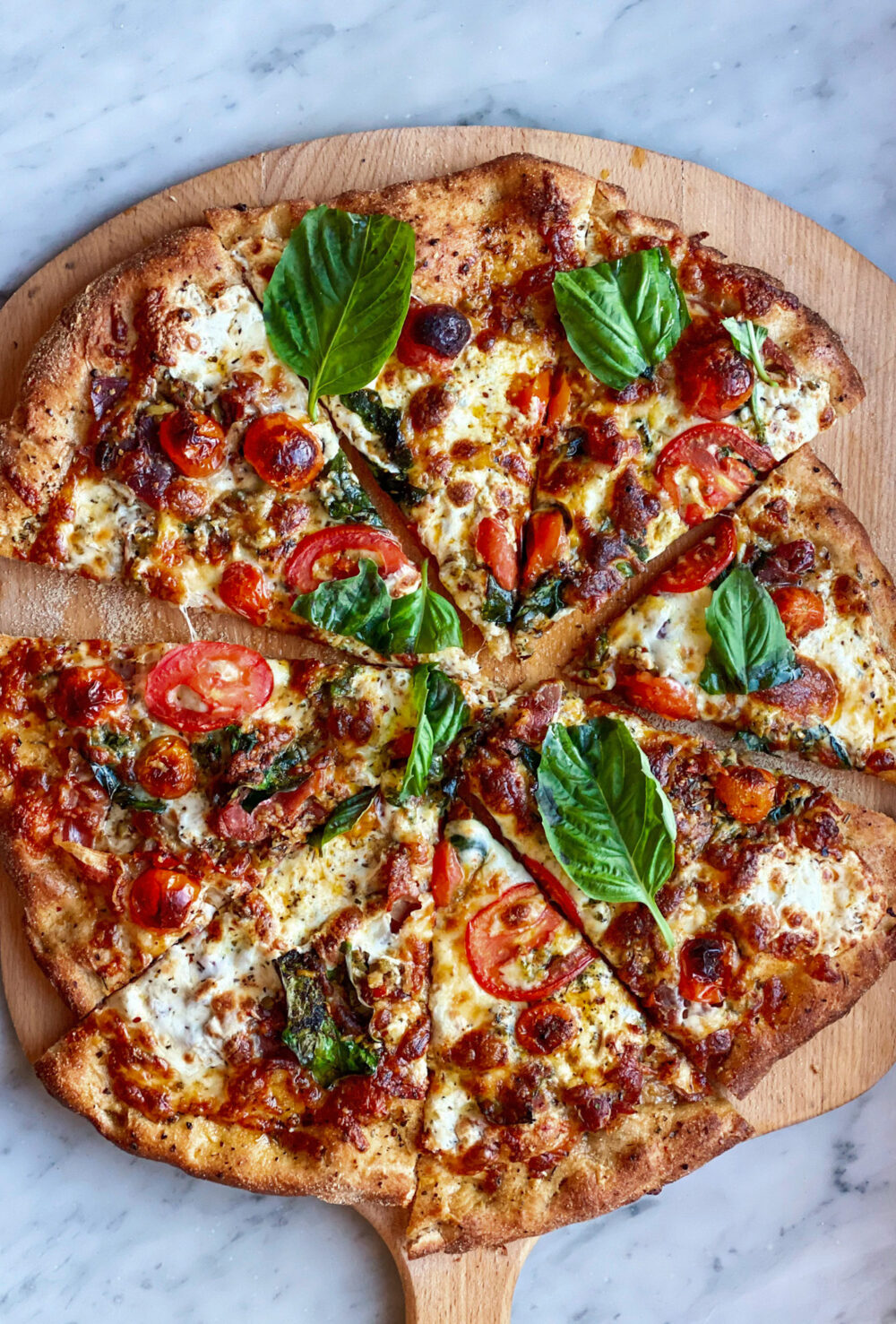 Pizza sliced and on a peel made with Trader Joe's pizza dough