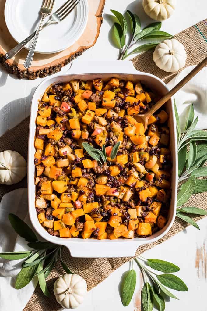 Paleo Buttnernut squash and sausage stuffing in a dish withsage and a spoon