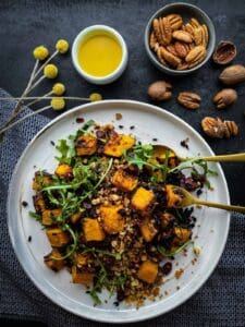 Vegan butternut squash salad on a white plate with dressing