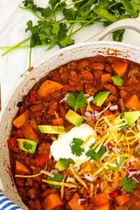 Butternut squash chili with avocados and sourcream on top