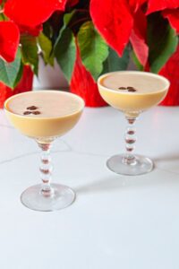 2 eggnog espresso martinis in front of poinsettias