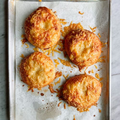 4 asiago cheese bagels on a parchment lined baking sheet