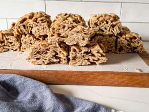 Cut up cinnamon toast crunch treats on a cutting board with parchment