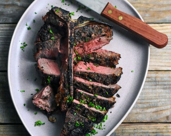 t-bone steak sliced on a plate with a steak knife