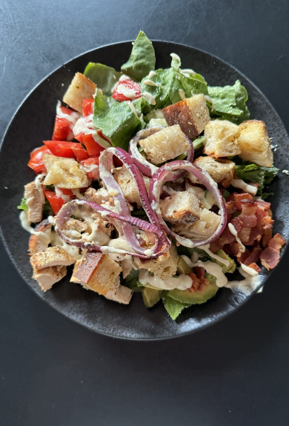 california blt caesar salad on a black plate
