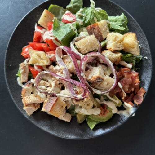 california blt caesar salad on a black plate