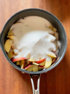 pink apples in a pan with sugar