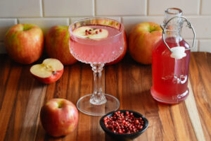 pink apple syrup with pink pepper corns and apples and pink apple martini