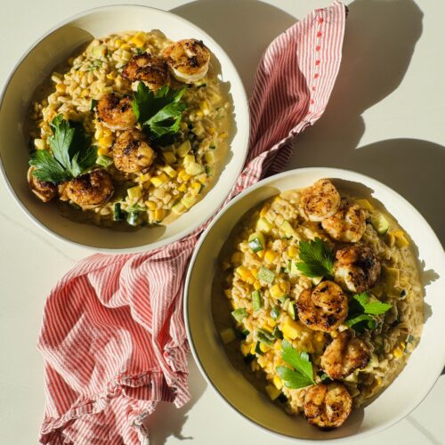 2 bowls of corn and zucchini and summer squash risotto and a red and white napkin