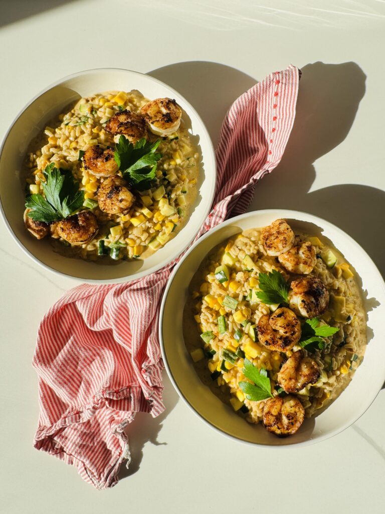 2 bowls of corn and zucchini and summer squash risotto and a red and white napkin