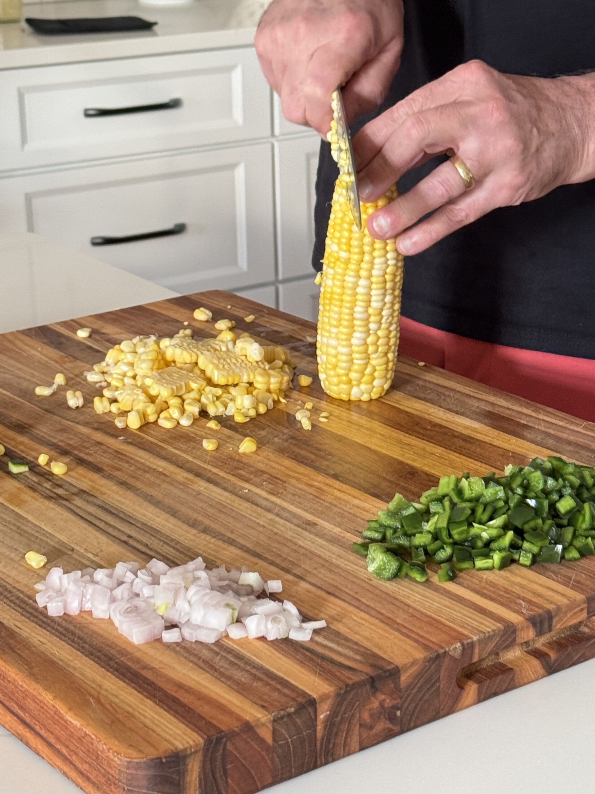 fresh corn on cob being sliced off