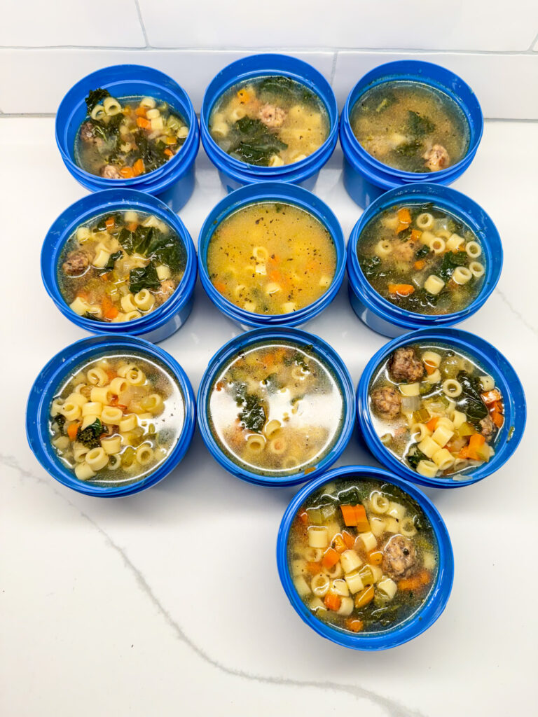 Italian wedding soup cooling in blue containers