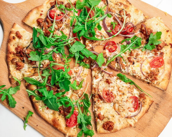 Italian Chicken Sausage pizza sliced with arugula