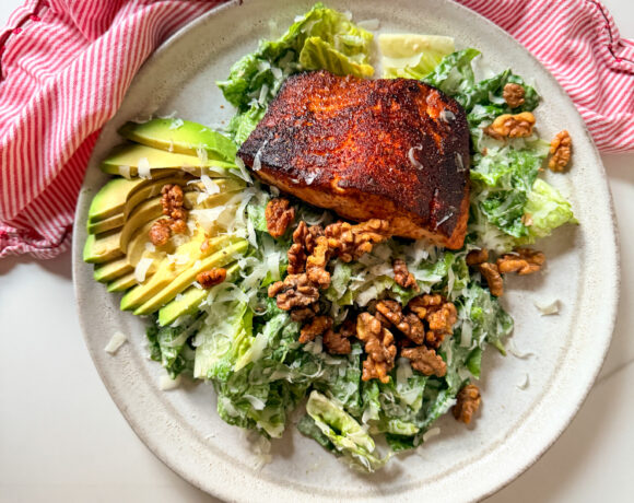 Blackened salmon on a salad with avocado and walnuts