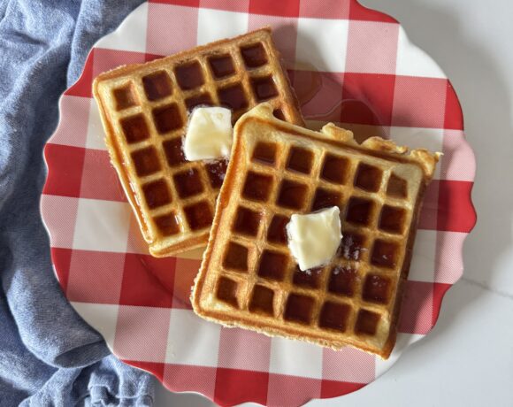 Fluffy Buttermilk Waffles on a red and white plate with a blue napkin